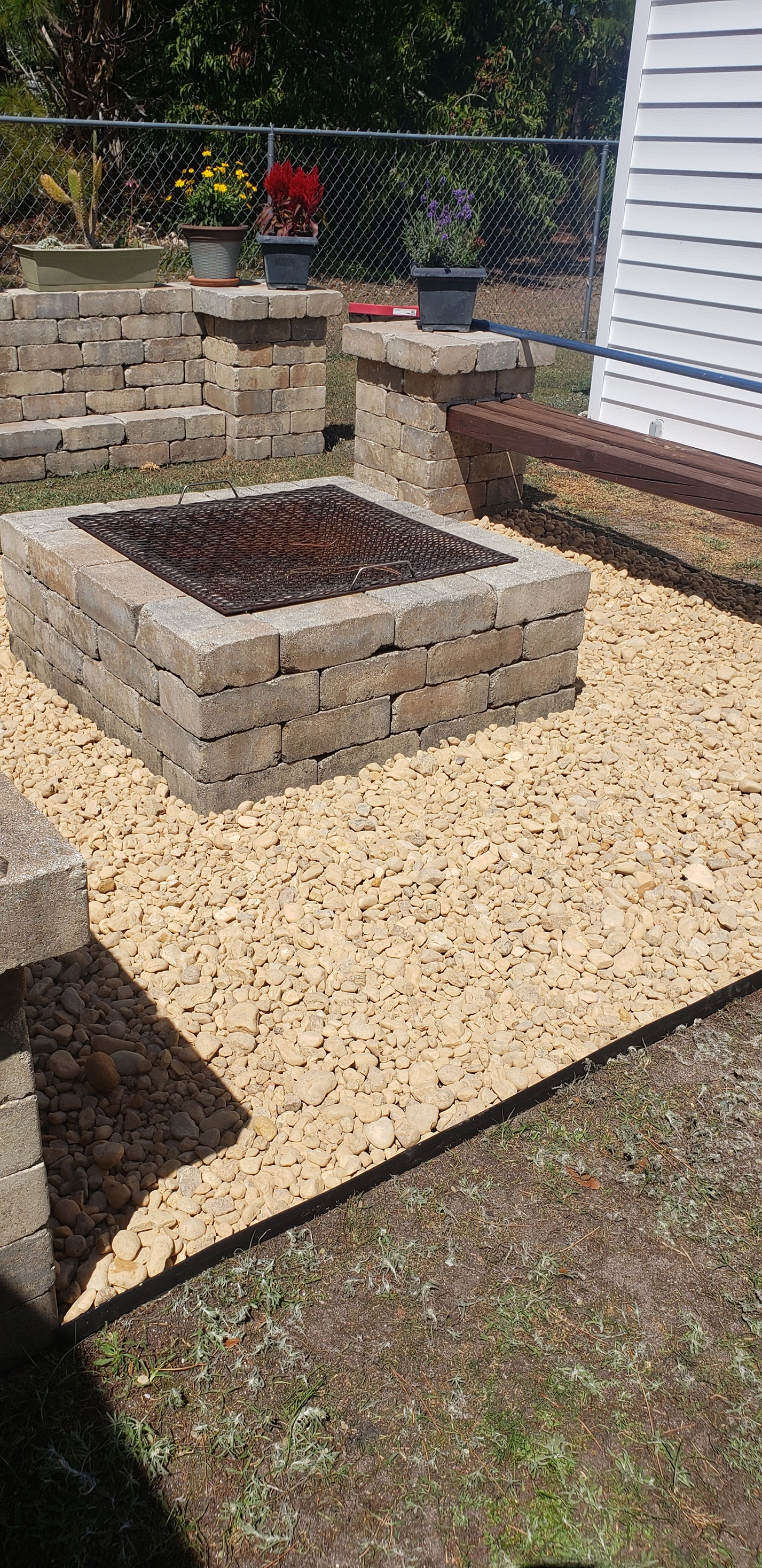 A fire pit in a backyard surrounded by rocks