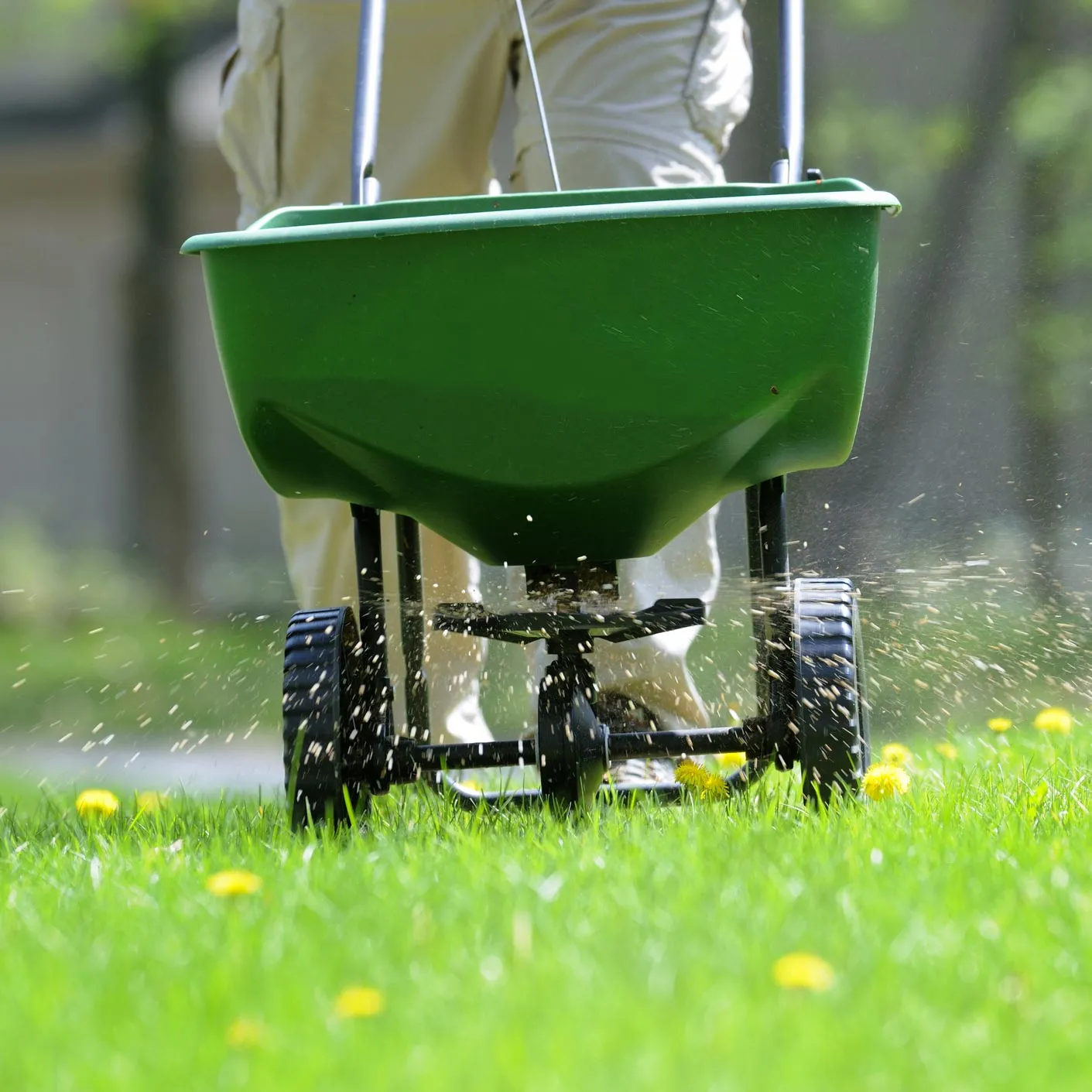 A man is pushing a wheelbarrow in the grass